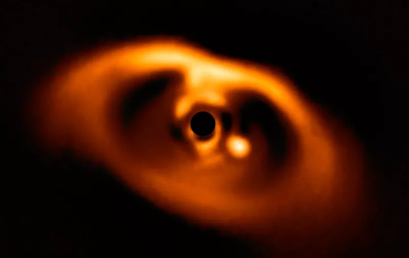 This spectacular image from the SPHERE instrument on ESO's Very Large Telescope is the first clear image of a planet caught in the very act of formation around the dwarf star PDS 70. The planet stands clearly out, visible as a bright point to the right of the centre of the image, which is blacked out by the coronagraph mask used to block the blinding light of the central star.