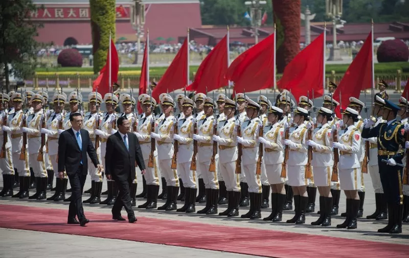 Cambodia's Prime Minister Hun Sen (C) reviews a military honour guard with Chinese Premier Li Keqiang (L) during a welcome ceremony outside the Great Hall of the People in Beijing on May 16, 2017.
Hun Sen is on a state visit to China after attending the Belt and Road Forum on May 14-15. / AFP PHOTO / NICOLAS ASFOURI