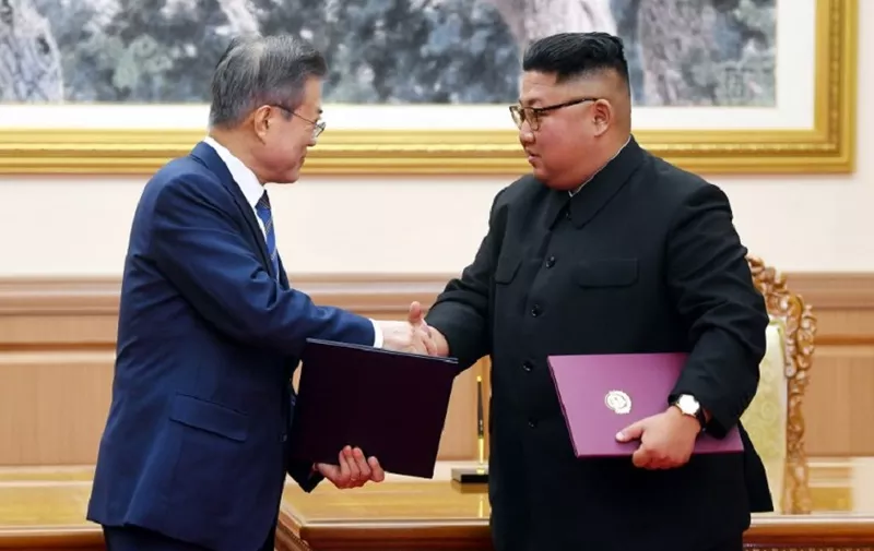 South Korean President Moon Jae-in (L) exchanges documents with North Korean leader Kim Jong Un (R) during a signing ceremony after their summit at Paekhwawon State Guesthouse in Pyongyang on September 19, 2018.
North Korean leader Kim Jong Un will make a historic visit to Seoul "in the near future", he said on September 19, after a summit with the South's Moon Jae-in in Pyongyang. / AFP PHOTO / Pyeongyang Press Corps / - / RESTRICTED TO EDITORIAL USE - MANDATORY CREDIT "AFP PHOTO / Pyeongyang Press Corps" - NO MARKETING NO ADVERTISING CAMPAIGNS - DISTRIBUTED AS A SERVICE TO CLIENTS