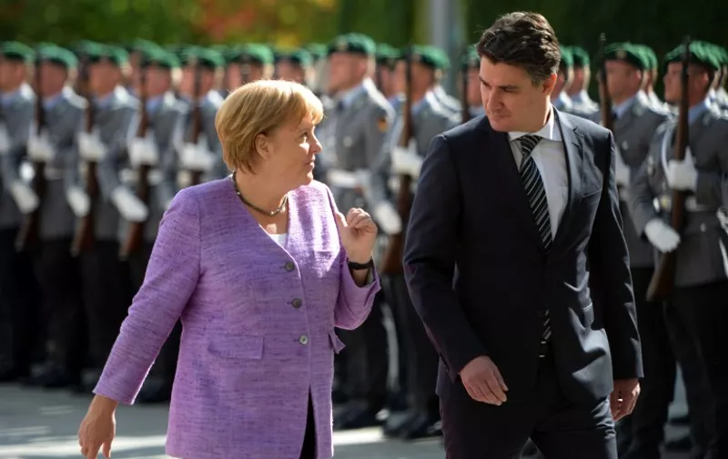 German Chancellor Angela Merkel and Croatian Prime Minister Zoran Milanovic inspect a military honor guard at the Chancellery in Berlin on September 19, 2012.  AFP PHOTO / JOHANNES EISELE