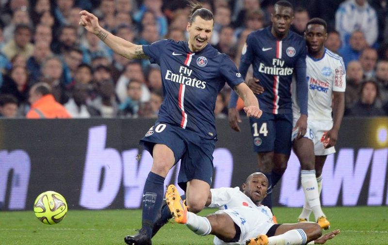 Paris Saint-Germain&#8217;s Swedish midfielder Zlatan Ibrahimovic (L) vies for the ball with Marseille&#8217;s French defender Rod Fanni (DOWN) during the French L1 football match between Marseille (OM) and Paris (PSG) on April 5, 2015 at the Velodrome stadium in Marseille, southern France. AFP PHOTO / BORIS HORVAT