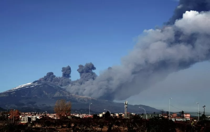 Smoke rises over the city of Catania during an eruption of the Mount Etna, one of the most active volcanoes in the world on December 24, 2018. (Photo by GIOVANNI ISOLINO / AFP)