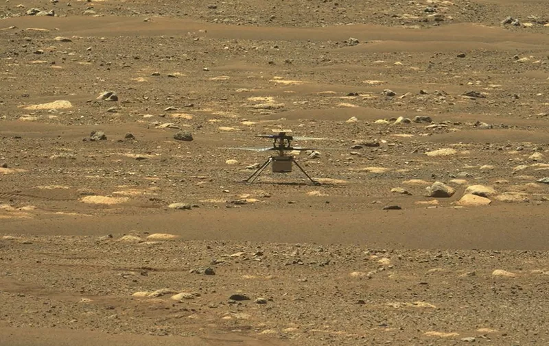 This NASA photo was taken after the first flight of NASA's Ingenuity Mars Helicopter  and the first powered, controlled flight on another planet,  captured by Mastcam-Z, a pair of zoomable cameras aboard NASA's Perseverance Mars rover, on April 19, 2021. - Flying in a controlled manner on Mars is far more difficult than flying on Earth. Mars has significant gravity (about one-third that of Earth's), but its atmosphere is just 1 percent as dense as Earth's at the surface. Stitched together from multiple images, the mosaic is not white balanced; instead, it is displayed in a preliminary calibrated version of a natural color composite, approximately simulating the colors of the scene that we would see if we were there viewing it ourselves. (Photo by Handout / NASA/JPL-Caltech/MSSS/ASU / AFP) / RESTRICTED TO EDITORIAL USE - MANDATORY CREDIT "AFP PHOTO / NASA/JPL-Caltech/MSSS/ASU/HANDOUT" - NO MARKETING - NO ADVERTISING CAMPAIGNS - DISTRIBUTED AS A SERVICE TO CLIENTS
