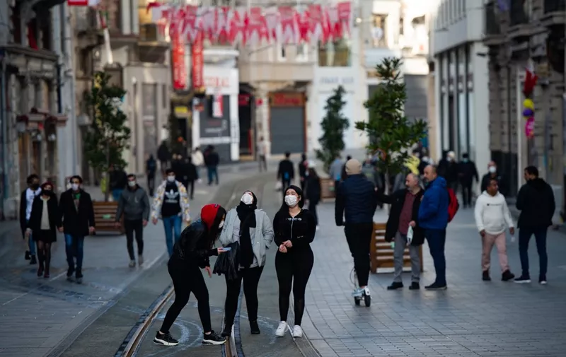 People laugh in the Istiklal street during a two-day curfew to limit the spread of the Covid-19 disease in Istanbul, on January 31, 2021. (Photo by Yasin AKGUL / AFP)