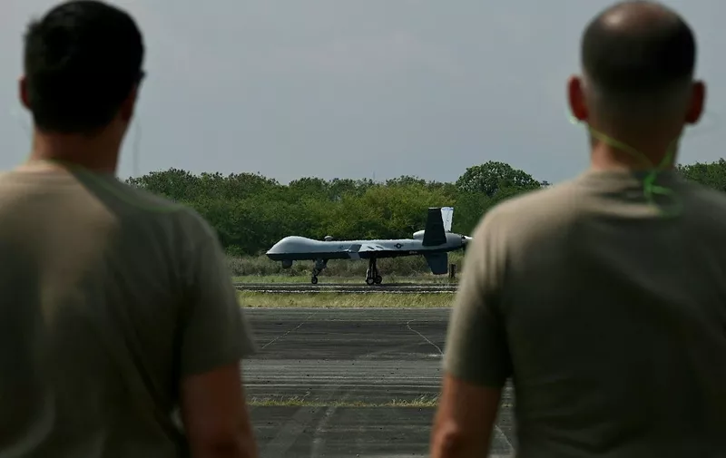 US soldiers watch as MQ-9 Reaper drone lands at Subic Bay Freeport Zone on April 23, 2023, as part of the US-Philippines joint military exercise Balikatan. (Photo by JAM STA ROSA / AFP)