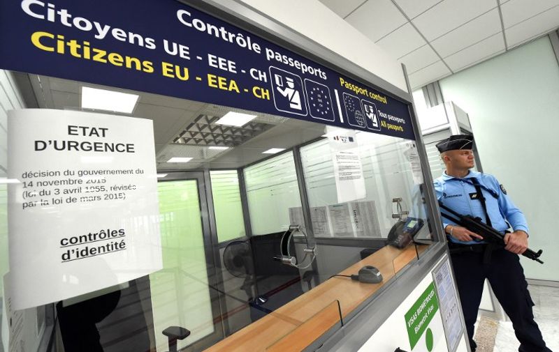 A French Gendarme stands guard at the passport control of the airport in Montpellier, southern France, on November 20, 2015. The European Union agreed on November 20 to rush through reforms to the passport-free Schengen zone by the end of the year amid growing concerns about border security in the wake of the Paris attacks. The November 13 Paris attacks left 130 people dead and over 350 injured. The placard at left reads "State of Emergency". AFP PHOTO / PASCAL GUYOT / AFP / PASCAL GUYOT