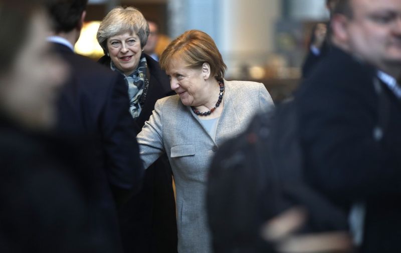 German Chancellor Angela Merkel (C) and Britain's Prime Minister Theresa May (C-L) greet delegation members at the Chancellery in Berlin on December 11, 2018. - Embattled British Prime Minister Theresa May launched a tour of European capitals in a desperate bid to salvage her Brexit deal, a day after delaying a parliamentary vote on the text to avoid a crushing defeat. (Photo by Odd ANDERSEN / AFP)