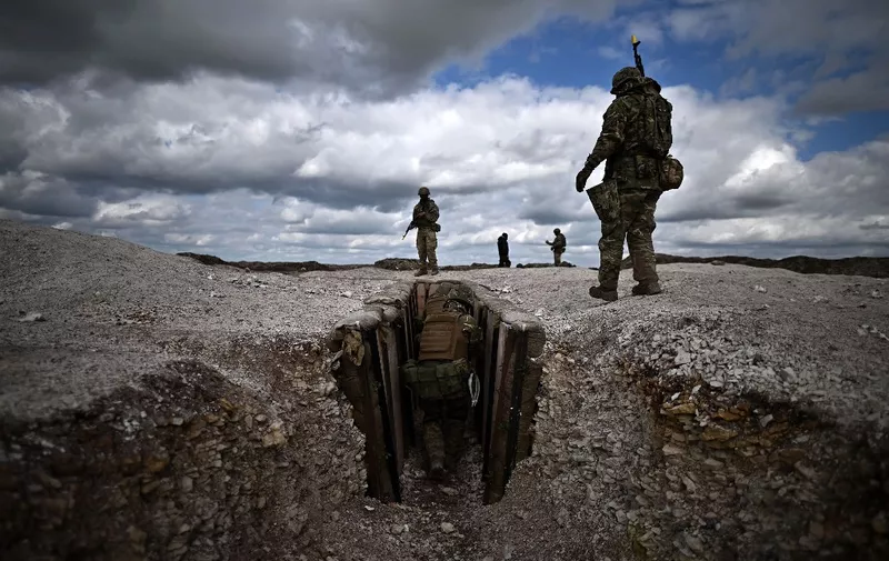 Member of New Zealand's armed forces personnel (top C and R) instruct Ukraine Army recruits as they take part in a trench warfare training session at a British Ministry of Defence (MOD) training base in southern England on March 27, 2023. (Photo by Ben Stansall / AFP)