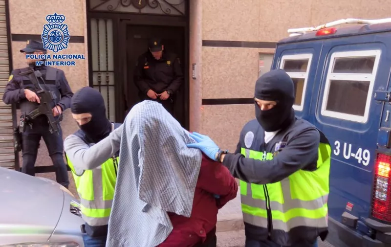 A handout picture released on February 7, 2016 by Spanish National Police shows masked police officers taking an arrested person at an undisclosed location. Spanish police said they arrested seven people today with suspected links to Al-Qaeda and the Islamic State jihadist groups in the eastern cities of Valencia and Alicante and in Spain's North African enclave of Ceuta.   AFP PHOTO / POLICIA NACIONAL

RESTRICTED TO EDITORIAL USE - MANDATORY CREDIT "AFP PHOTO / POLICIA NACIONAL" NO MARKETING NO ADVERTISING CAMPAIGNS - DISTRIBUTED AS A SERVICE TO CLIENTS / AFP / POLICIA NACIONAL / -