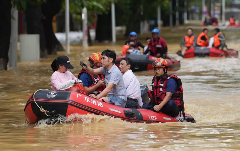 Rescue workers carry residents on boats through a street flooded by heavy rains from Typhoon Sanba in Maoming, in Chinas southern Guangdong province on October 21, 2023. (Photo by AFP) / China OUT