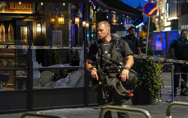 A norwegian police officer stands guard in the streets of central Oslo between security tape lines, on June 25, 2022, after shots were fired outside the London pub, killing two people. - Police said a suspect had been arrested following the shootings, which occurred around 1:00 am (2300 GMT Friday) in three locations, including a gay bar, in the centre of the Norwegian capital. Police reported two dead and 14 wounded, and said two weapons had been seized. (Photo by Javad Parsa / NTB / AFP) / Norway OUT