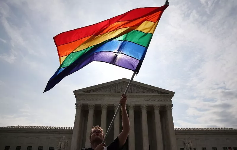 WASHINGTON, DC - JUNE 25: A gay marriage waves a flag in front of the Supreme Court Building June 25, 2015 in Washington, DC. The high court is expected rule in the next few days on whether states can prohibit same sex marriage, as 13 states currently do.   Mark Wilson/Getty Images/AFP