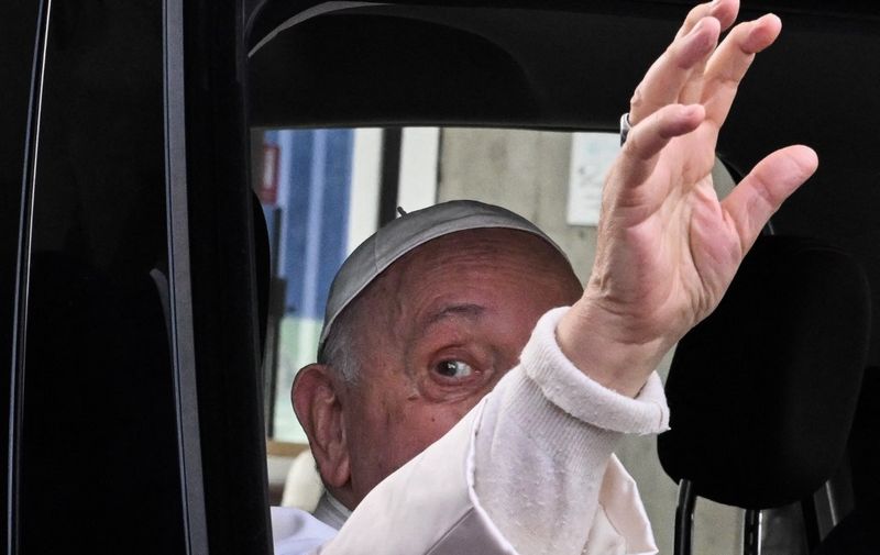 Pope Francis waves as he leaves the Gemelli hospital on April 1, 2023 in Rome, after being discharged following treatment for bronchitis. - The 86-year-old pontiff was admitted to Gemelli hospital on March 29 after suffering from breathing difficulties. (Photo by Tiziana FABI / AFP)