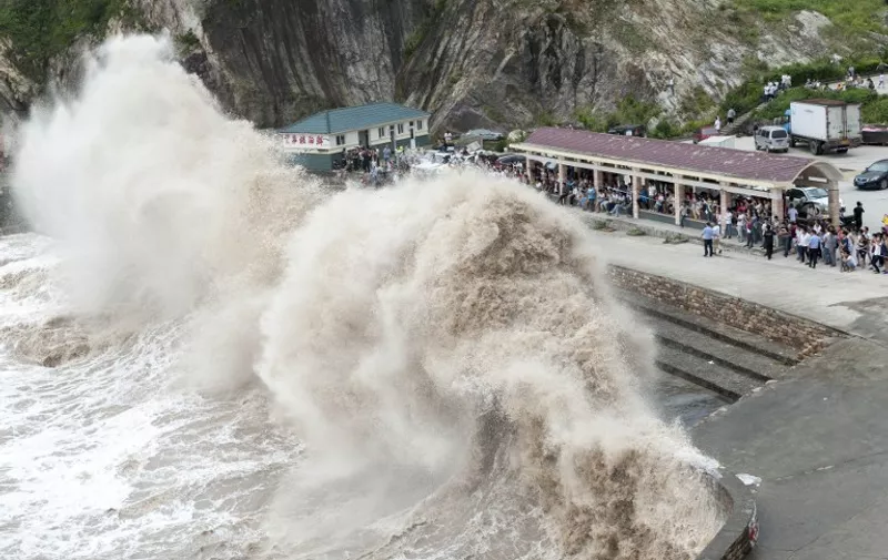 People gather to see huge waves as typhoon Chan-hom comes near Wenling, east China's Zhejiang province on July 10, 2015. Typhoon Chan-hom lashed Japan's Okinawa island chain on July 10 as it pushed towards Taiwan and onto China, leaving more than 20 people injured. CHINA OUT   AFP PHOTO