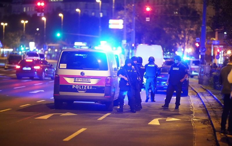 Police cars and armed police offficer stand in central Vienna on November 2, 2020, following a shooting near a synagogue. - Multiple gunshots were fired in central Vienna on the evening of November 2, 2020, according to police, with the location of the incident close to a major synagogue. Police urged residents to keep away from all public places or public transport. One attacker was "dead" and another "on the run", with one police officer being seriously injured, Austria's interior ministry said according to news agency APA. (Photo by GEORG HOCHMUTH / APA / AFP) / Austria OUT