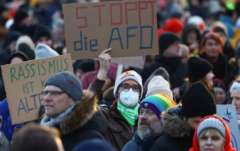 A participant holds up a placard reading 'Stop AfD' during a demonstration against racism and far right politics in front of the Reichstag building in Berlin, Germany on January 21, 2024. Tens of thousands of people were expected to turn out again on January 21 to protest against the far-right AfD, after it emerged that party members discussed mass deportation plans at a meeting of extremists. (Photo by CHRISTIAN MANG / AFP)