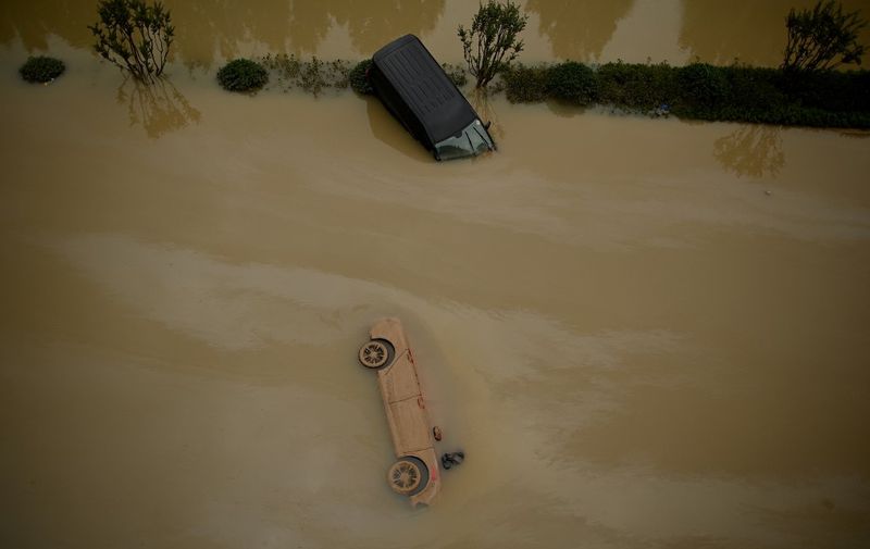 Cars sit in floodwaters following heavy rains, in Zhengzhou in China's central Henan province on July 22, 2021. (Photo by Noel Celis / AFP)