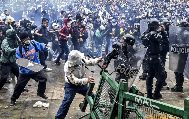 Demonstrators clash with riot police during a protest against a tax reform bill launched by Colombian President Ivan Duque, in Bogota, on April 28, 2021. - Workers' unions, teachers, civil organizations, indigenous people and other sectors reject the project that is underway in the Congress, considering that it punishes the middle class and is inappropriate in the midst of the crisis unleashed by the COVID-19 pandemic. (Photo by Juan BARRETO / AFP)