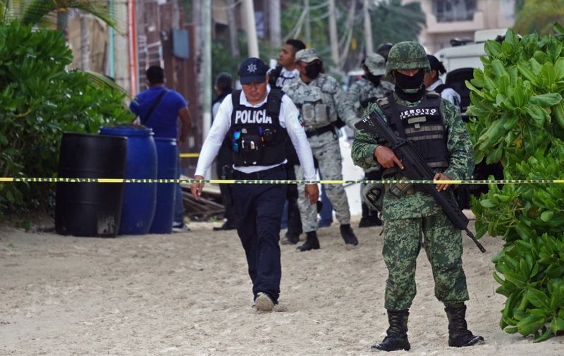 Members of the Mexican Navy and local police guard a restaurant after an explosion in the tourist area of Playa Mamitas, in Playa del Carmen, Quintana Roo State, Mexico, on March 14, 2022. - State authorities reported two people dead and 19 injured. (Photo by ELIZABETH RUIZ / AFP)