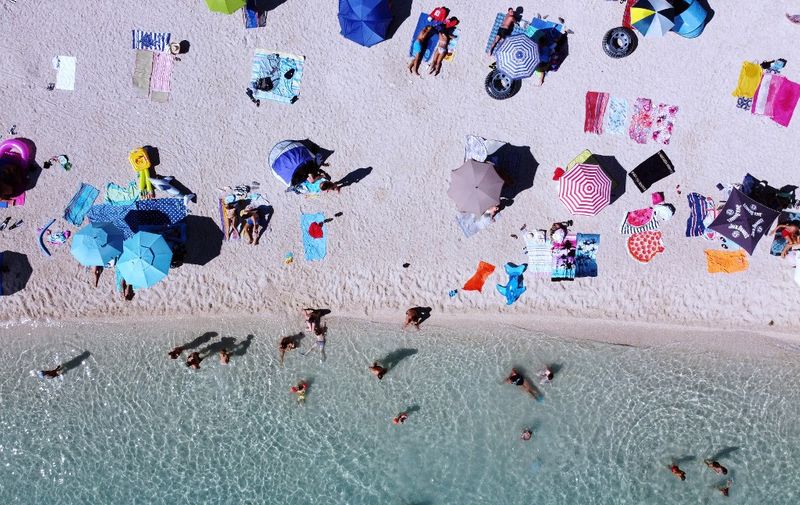 An aerial picture shows crowds of people, including foreign tourists, enjoying the sun and the sea on August 21, 2020, in Split on the central Adriatic coast. - As United Kingdom removed Croatia from the list of "safe countries" to travel due to rising number of cases of COVID-19 throughout the country, many British tourists arrived at airport to return back to their country because of stricter measures when returning from Croatia. (Photo by Damir SENCAR / AFP)