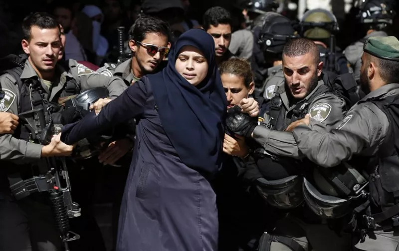 TOPSHOTS
Israeli security forces arrest a Palestinian woman during clashes between Palestinian protesters and Israeli police after authorities limited access for Muslim worshipers to the flashpoint al-Aqsa mosque compound in the old city of Jerusalem on July 26, 2015. Israeli police entered the compound, one of Islam's holiest places, to tackle suspected Palestinian rioters, police said. AFP PHOTO / AHMAD GHARABLI