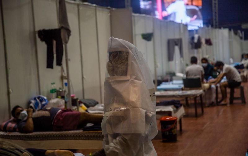NEW DELHI, INDIA - JULY 17: Indian health worker in a hazmat suit attends to Covid-19 patients in an indoor sports stadium, temporarily been converted into an emergency Covid 19 care center on July 17, 2020  in New Delhi, India. With the highest single-day surge of 34,956 cases, Indias confirmed Covid-19 infections crossed the 1 million mark as the worlds third worst hit country grapples to deal with the impact of the global epidemic. Even as death toll due to the deadly virus mounted to 25,602 with record 687 fatalities in a day, according to data released by the health ministry on early Friday, Indian Prime Minister Narendara Modi in a televised address said the country was ensuring one of the best recovery rates in the world in its fight against Covid-19. (Photo by Yawar Nazir/Getty Images)