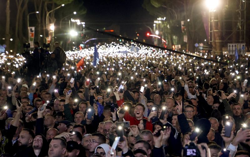 Protesters hold up flashlights from their mobile phones during an anti-government rally in front of government headquarters in Tirana on November 12, 2022. (Photo by Gent SHKULLAKU / AFP)