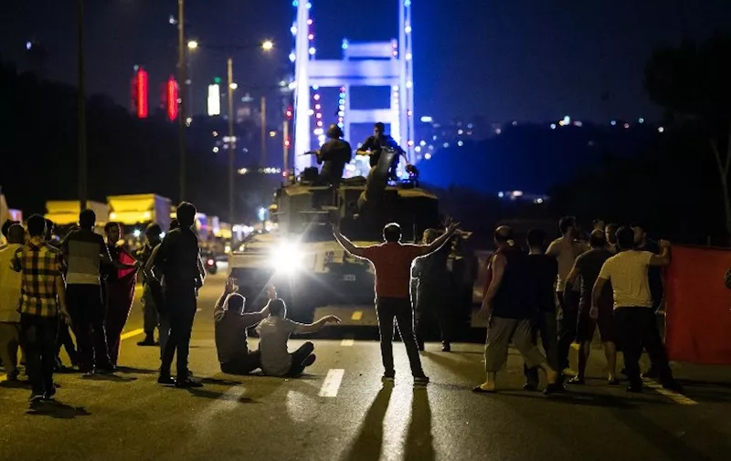 EDITORS NOTE: Graphic content / (FILES) In this file photo taken on July 15, 2016, people take over a tank near the Fatih Sultan Mehmet bridge during clashes with military forces in Istanbul.
Turkish authorities ordered on July 8, 2018 the dismissal of more than 18,500 state employees, including police officers, soldiers and academics, ahead of the expected end of a two-year state of emergency since the failed coup attempt. / AFP PHOTO / GURCAN OZTURK
