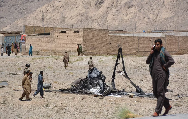 Pakistani security officials gather around the wreckage of an army aviation helicopter after a crash landing on the outskirts of Quetta on June 7, 2018. - A Frontier Corps (FC) soldier was killed and two others were injured when an army helicopter crash-landed on the outskirts of Quetta. (Photo by BANARAS KHAN / AFP)