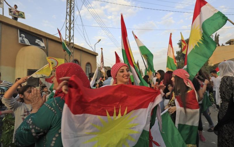 Syrian Kurds dance with the Kurdish flag as they celebrate in the northeastern Syrian city of Qamishli on September 25, 2017, in support of the independence referendum in Iraq's autonomous northern Kurdish region.
Iraqi Kurds voted in an independence referendum, defying warnings from Baghdad and their neighbours in a historic step towards a national dream. / AFP PHOTO / Delil souleiman