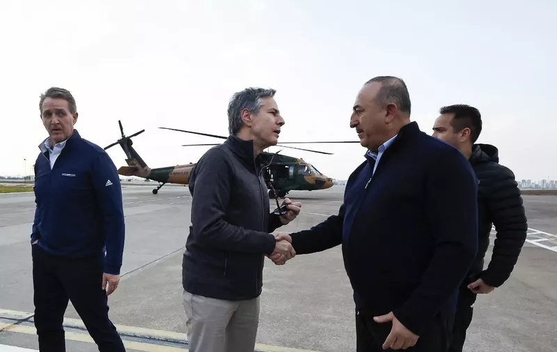 US Secretary of State Antony Blinken (C) shakes hands with Turkish Foreign Minister Mevlut Cavusoglu after a helicopter tour of earthquake stricken areas on February 19, 2023, during an official visit after a 7,8-magnitude earthquake struck Turkey's south-east. - The death toll on February 18 rose to more than 44,000 from the devastating earthquake in Turkey and Syria in the early hours of February 6, 2023. (Photo by CLODAGH KILCOYNE / POOL / AFP)
