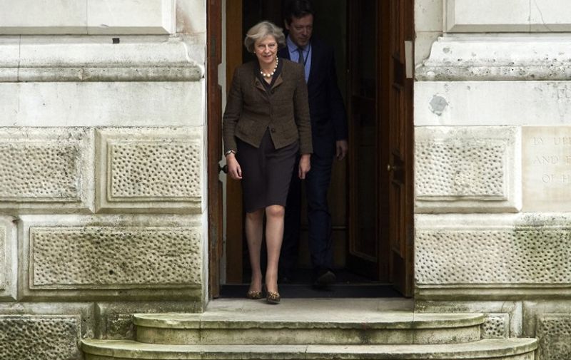 British Prime Minister Theresa May (L) walks out of the Foreign and Commonwealth Office (FCO) in central London on October 14, 2016. 
British Prime Minister Theresa May announced earlier this month her government will trigger those negotiations by the end of March, putting the country on course to leave the EU by early 2019. / AFP PHOTO / NIKLAS HALLE'N