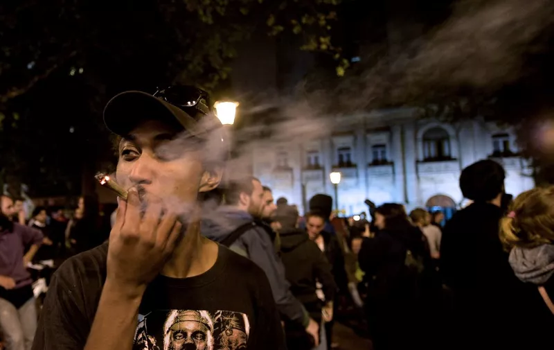 A man smokes marijuana during the Global Marijuana March (GMM) in Montevideo on May 4, 2018. (Photo by MIGUEL ROJO / AFP)