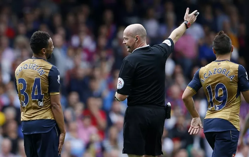 Referee Lee Mason speaks to Arsenal's French midfielder Francis Coquelin (L) during the English Premier League football match between Crystal Palace and Arsenal at Selhurst Park in south London on August 16, 2015. Arsenal won the game 2-1. AFP PHOTO / ADRIAN DENNIS

RESTRICTED TO EDITORIAL USE. No use with unauthorized audio, video, data, fixture lists, club/league logos or 'live' services. Online in-match use limited to 75 images, no video emulation. No use in betting, games or single club/league/player publications.