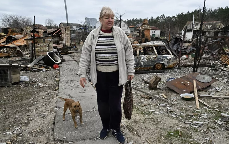 Natalia, 62, stands in front of her destroyed house in the village of Moshchun, northwest of Kyiv, on April 20, 2022, as more than five million Ukrainians have now fled their country following the Russian invasion, the United Nations says. - UNHCR, the UN refugee agency, says 5,034,439 Ukrainians have left since Russia invaded on February 24. Over a million Ukrainians have in contrast returned to their country since the Russian invasion began, says a spokesman for Kyiv's border force. (Photo by Genya SAVILOV / AFP)