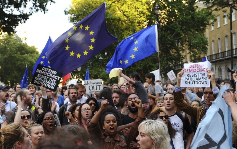 Demonstrators wave European Union flags and hold placards as they protest outside of Downing Street in London on August 28, 2019. - British Prime Minister Boris Johnson sparked fury Wednesday among pro-Europeans and MPs opposed to a no-deal Brexit by forcing the suspension of parliament weeks before Britain's EU departure date. The pound slid on the surprise news, which opponents branded a "coup" and a "declaration of war" but Johnson claimed was necessary to allow him to pursue a "bold and ambitious" new domestic legislative agenda. (Photo by DANIEL SORABJI / AFP)