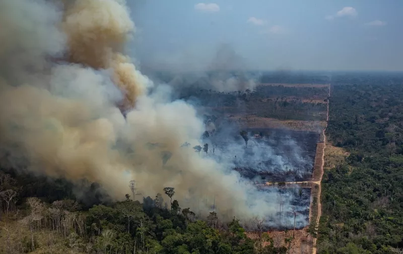 Handout aerial picture released by Greenpeace showing smoke billowing from forest fires in the municipality of Candeias do Jamari, close to Porto Velho in Rondonia State, in the Amazon basin in northwestern Brazil, on August 24, 2019. - Brazil on August 25 deployed two Hercules C-130 aircraft to douse fires devouring parts of the Amazon rainforest. The latest official figures show 79,513 forest fires have been recorded in the country this year, the highest number of any year since 2013. More than half of those are in the massive Amazon basin. Experts say increased land clearing during the months-long dry season to make way for crops or grazing has aggravated the problem this year. (Photo by Victor MORIYAMA / GREENPEACE / AFP) / RESTRICTED TO EDITORIAL USE - MANDATORY CREDIT "AFP PHOTO / GREENPEACE / VICTOR MORIYAMA" - NO MARKETING - NO ADVERTISING CAMPAIGNS - NO RESALE - NO ARCHIVE - IMAGE AVAILABLE FOR PUBLICATION AND DOWNLOAD UNTIL 09.09.2019 - DISTRIBUTED AS A SERVICE TO CLIENTS /