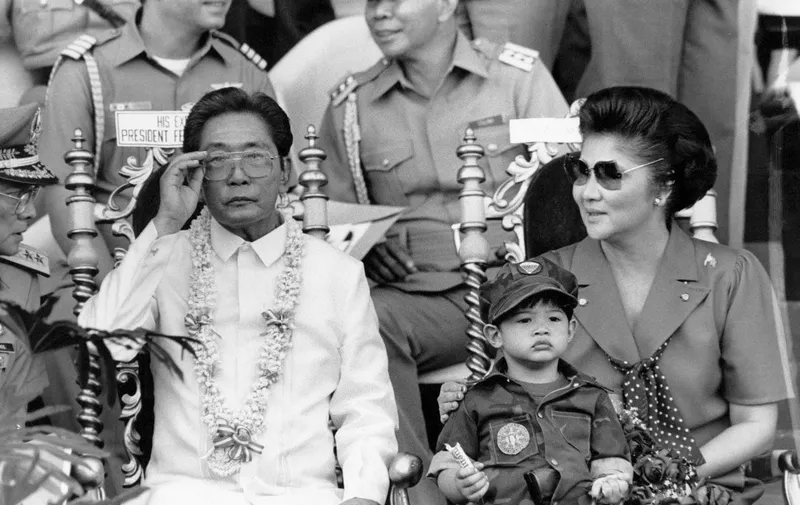 President Ferdinand Marcos and his wife Imelda appear 15 november 1985, before some 35.000 college students undergoing a two-year compulsory military training in Manila. (Photo by ROMEO GACAD / AFP)