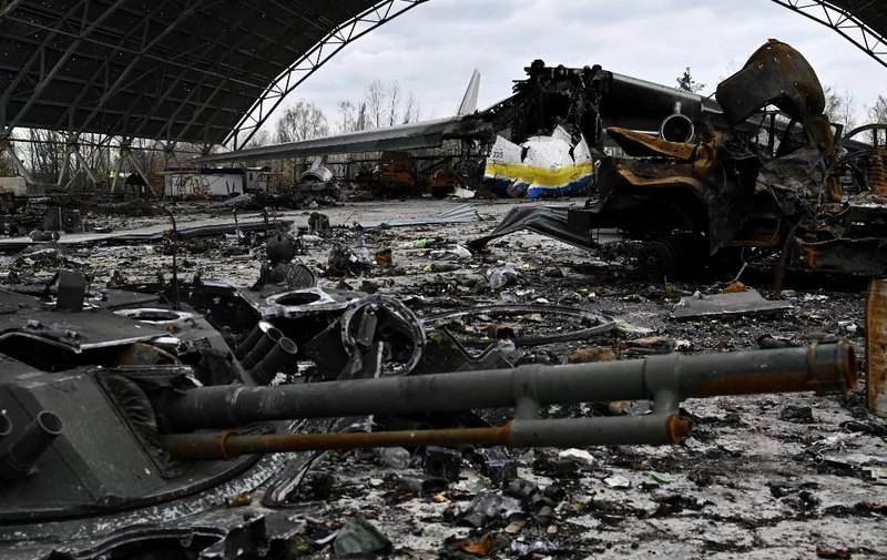 A picture shows the destroyed Ukrainian Antonov An-225 "Mriya" cargo aircraft, which was the largest plane in the world, among wreckage of charred Russian military vehicles, at the Hostomel airfield, northwest of the Ukrainian capital Kyiv on April 8, 2022, during Russia's military invasion launched on Ukraine. - The largest plane in the world -- Ukraine's Antonov-225 cargo plane -- was destroyed by Russian strikes outside Kyiv on the fourth day of Moscow's invasion, Ukraine's state-owned Ukroboronprom group said. The aircraft was unique to the world, at 84 meters long (276 feet) it could transport up to 250 tonnes (551,000 pounds) of cargo at a speed of up to 850 kilometres per hour (528 mph). (Photo by Genya SAVILOV / AFP)