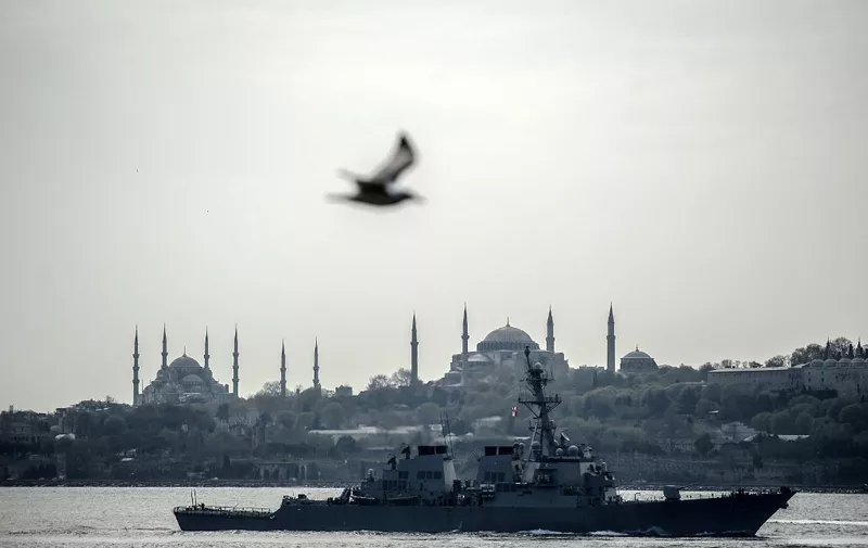 US warship,  USS Donald Cook, sails through the Bosporus in Istanbul, Turkey,  on April 10, 2014, en route to the Black Sea. According to a US Department of Defense press release, the guided missile destroyer's deployment is part of " the US commitment to mutual goals in the region," and that it will participate in operations and exercises in the area. The Blue Mosque is seen rear left. AFP PHOTO/BULENT KILIC (Photo by BULENT KILIC / AFP)