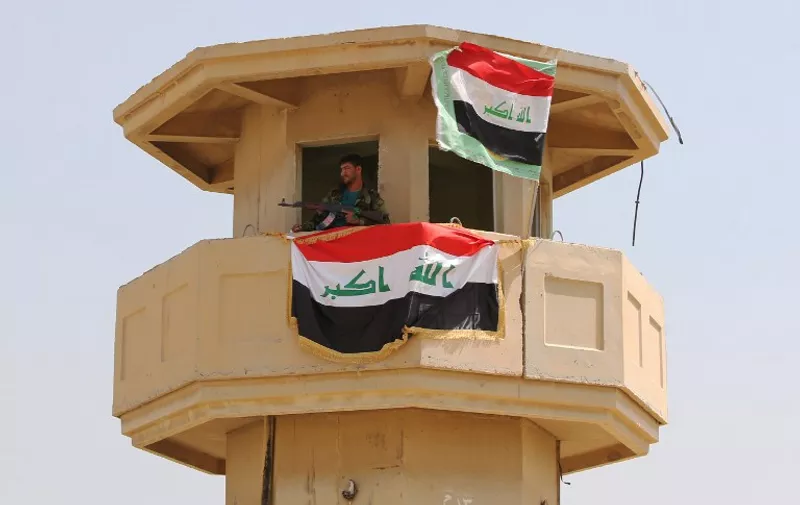 An Iraqi Shiite fighter and member of Iraq&#8217;s Popular Mobilisation Unit, stands inside a watchtower on April 9, 2015 located in the area of former Iraqi leader Saddam Hussein&#8217;s palace, in the city of Tikrit, after retaking it back from Islamic State group militia. AFP PHOTO / AHMAD AL-RUBAYE