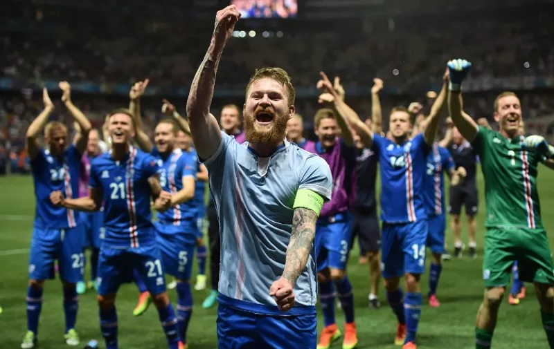Iceland's midfielder Aron Gunnarsson and team mates celebrate after the Euro 2016 round of 16 football match between England and Iceland at the Allianz Riviera stadium in Nice on June 27, 2016.  
Iceland won the match 1-2. / AFP PHOTO / BERTRAND LANGLOIS