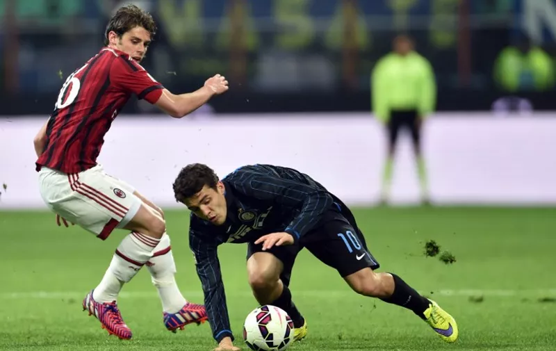 Inter Milan's midfielder from Croatia Mateo Kovacic  (R) fights for the ball with AC Milan's midfielder Andrea Poli during  their Italian Serie A football match  Inter Milan vs AC Milan at the San Siro Stadium in Milan on April 19, 2015 . AFP PHOTO / GIUSEPPE CACACE