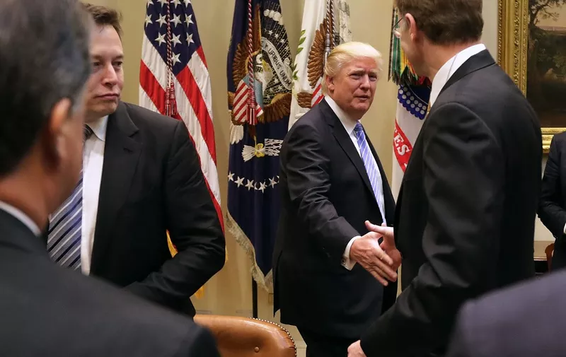 WASHINGTON, DC - JANUARY 23: U.S. President Donald Trump (C) greets Wendell Weeks (R) of Corning, Elon Musk of SpaceX (L) and other other business leaders as he arrives for a meeting in the Roosevelt Room at the White House January 23, 2017 in Washington, DC. Business leaders included Elon Musk of SpaceX, Wendell Weeks of Corning, Mark Sutton of International Paper, Andrew Liveris of Dow Chemical, Alex Gorsky of Johnston &amp; Johnson and others.   Chip Somodevilla/Getty Images/AFP (Photo by CHIP SOMODEVILLA / GETTY IMAGES NORTH AMERICA / Getty Images via AFP)