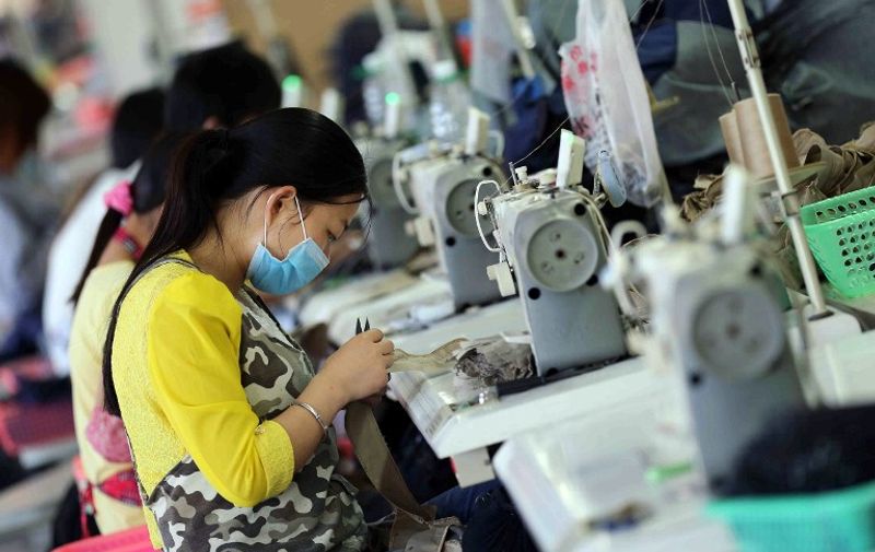 This picture taken on May 12, 2015 shows Chinese workers making jeans at a clothing factory in Shishi, east China's Fujian province. Retail sales growth in China fell to 10.0 percent in April, missing expectations and the lowest for nine years, while industrial output in the world's second-largest economy rose 5.9 percent in the same month, the National Bureau of Statistics said, while fixed asset investment, a measure of government spending on infrastructure, expanded 12.0 percent in the first four months of the year.              AFP PHOTO   CHINA OUT