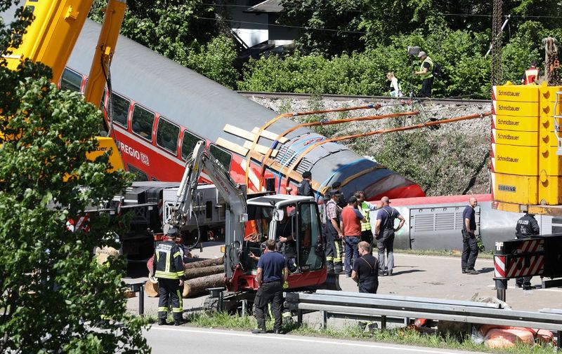 Rescue services and police are seen at work at the site of a derailed train near Burgrain, north of Garmisch-Partenkirchen, southern Germany, on June 4, 2022, a day after the accident. - A train derailed near a Bavarian Alpine resort in southern Germany on June 3, killing at least four people and injuring dozens in a region gearing up to host the G7 summit in late June. (Photo by Dominik BARTL / AFP)