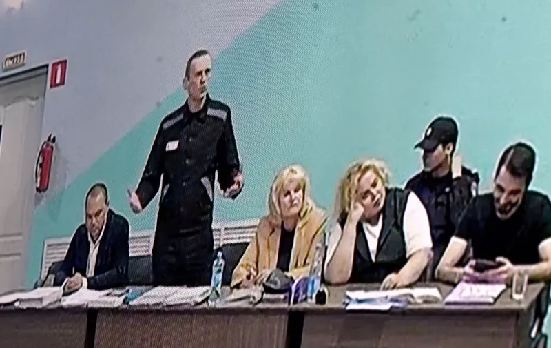Russian opposition leader Alexei Navalny (2nd L) is seen on a screen during court hearings in the IK-6 penal colony at Melekhovo, about 250 kilometres (155 miles) east of Moscow, where he is jailed on June 19, 2023. Jailed Kremlin critic Alexei Navalny went on trial on June 19 on "extremism" charges that could see his prison time extended for decades, as the Kremlin moves to silence dissenting voices. Navalny, who used to mobilise massive anti-Kremlin protests, is currently serving a nine-year prison sentence on embezzlement charges that his supporters see as punishment for his political work. (Photo by Natalia KOLESNIKOVA / AFP)