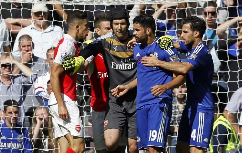 Arsenal's Brazilian defender Gabriel (L) and Chelsea's Brazilian-born Spanish striker Diego Costa (2nd R) are separated by Arsenal's Czech goalkeeper Petr Cech (C) as they clash during the English Premier League football match between Chelsea and Arsenal at Stamford Bridge in London on September 19, 2015. AFP PHOTO / IAN KINGTON 

RESTRICTED TO EDITORIAL USE. No use with unauthorized audio, video, data, fixture lists, club/league logos or 'live' services. Online in-match use limited to 75 images, no video emulation. No use in betting, games or single club/league/player publications.