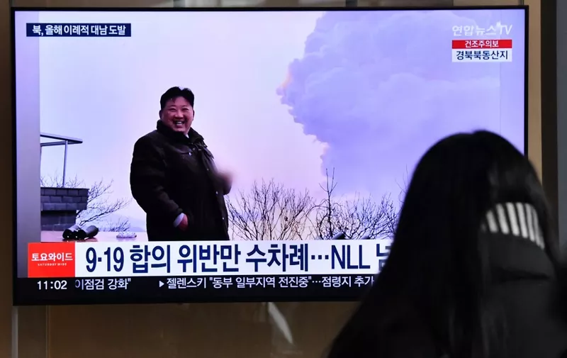 A woman watches a television screen showing a news broadcast with file footage of North Korean leader Kim Jong Un, at a railway station in Seoul on December 31, 2022 after North Korea fired three short-range ballistic missiles according to South Korea's military. (Photo by Jung Yeon-je / AFP)