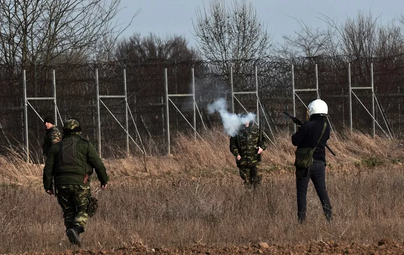 A Greek riot police officer lobs a tear gas canister during clashes with migrants along the Greece-Turkey border in the village of Kastanies on March 1, 2020. - Thousands more migrants reached the Turkish border with Greece on March 1, 2020, AFP journalists said, after the Turkish President threatened to let them cross into Europe. At least 2,000 people including women and children arrived on the morning from Istanbul and walked through a field towards the Pazarkule border gate, a correspondent said. The group included Afghans, Syrians and Iraqis. (Photo by Sakis MITROLIDIS / AFP)